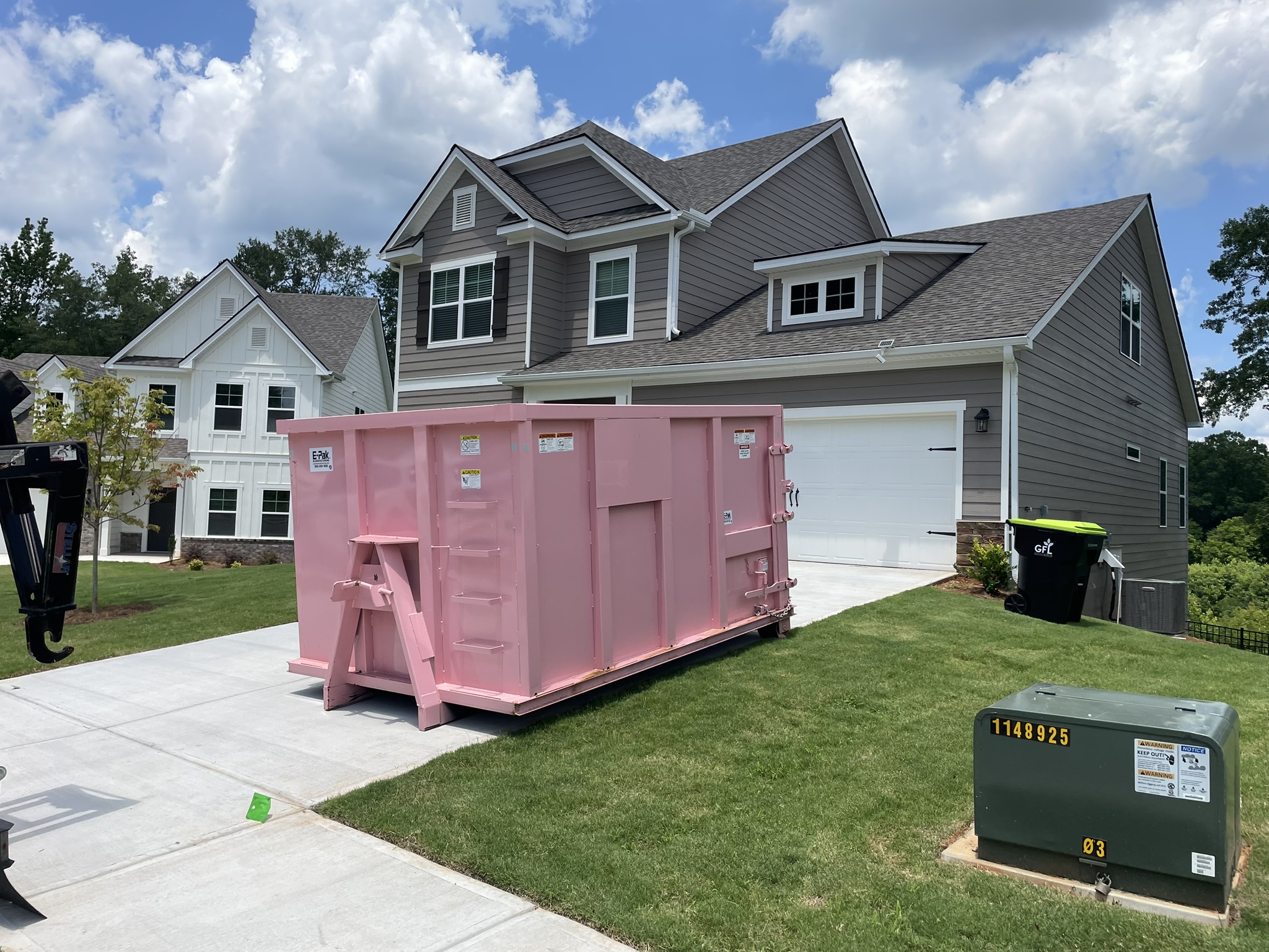 Pink 21-yard Big Junker dumpster placed in a residential driveway