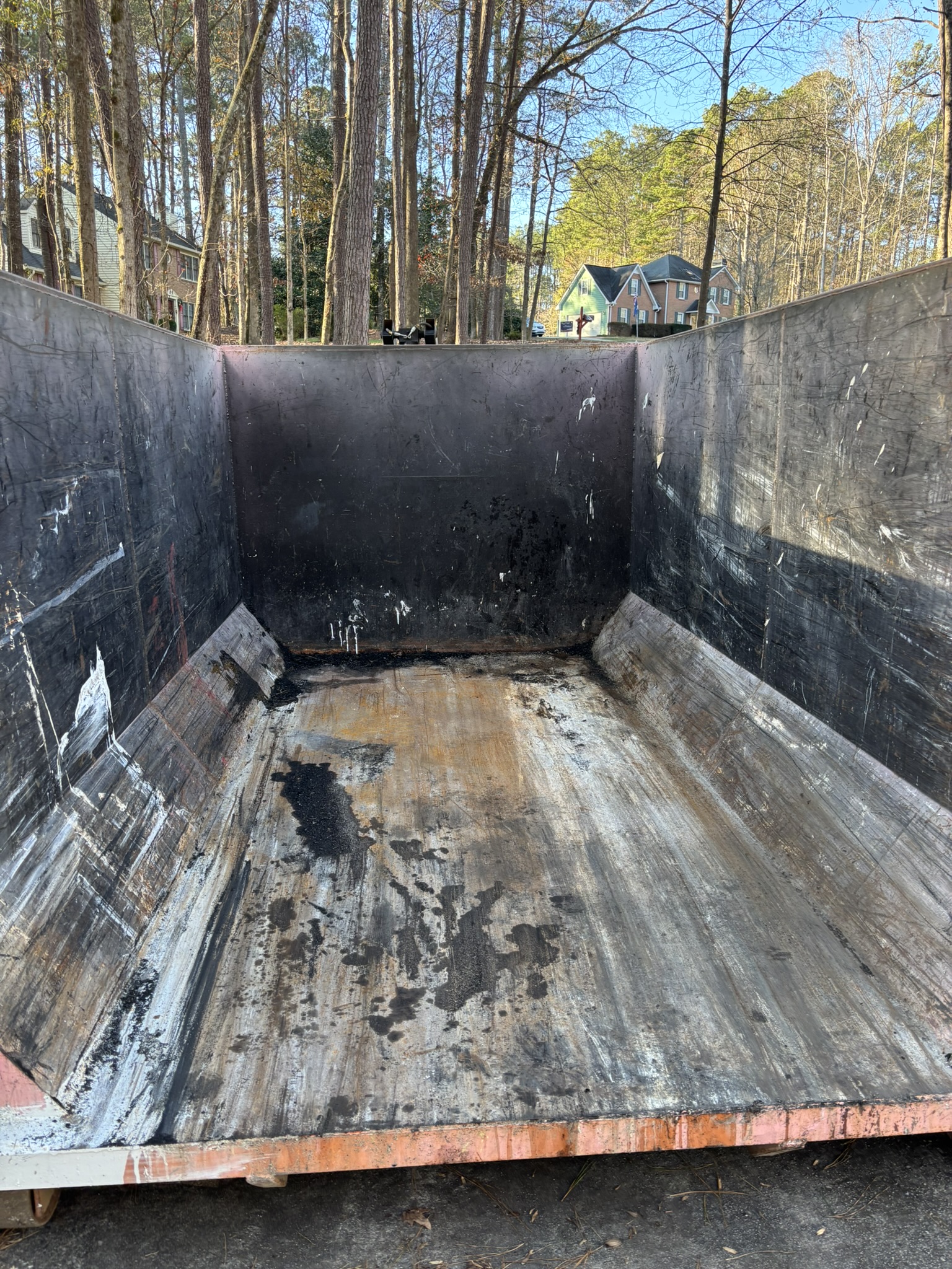 Interior of an empty 16-yard roll-off dumpster showing the open loading area